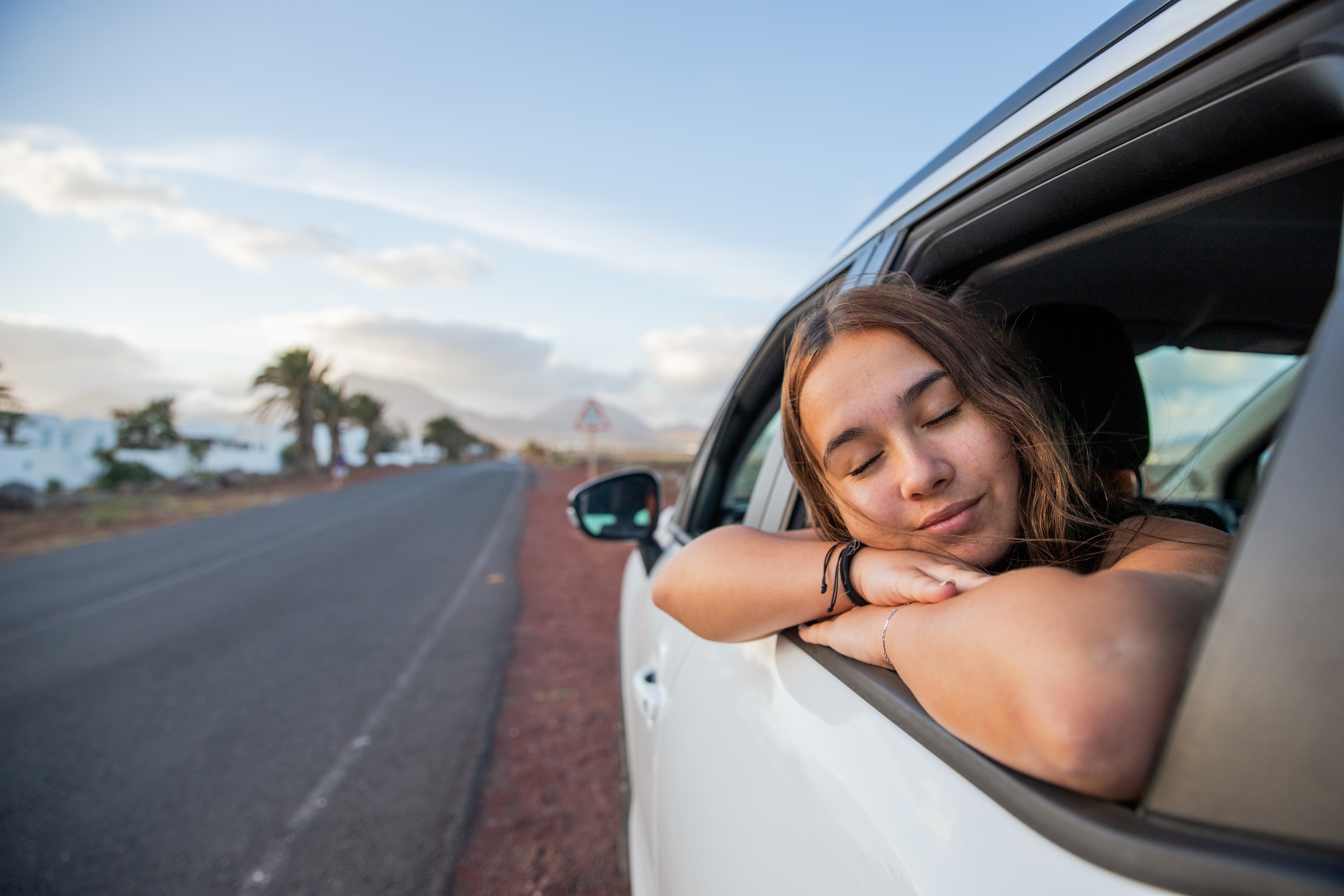 Chica asomándose por la ventana del coche